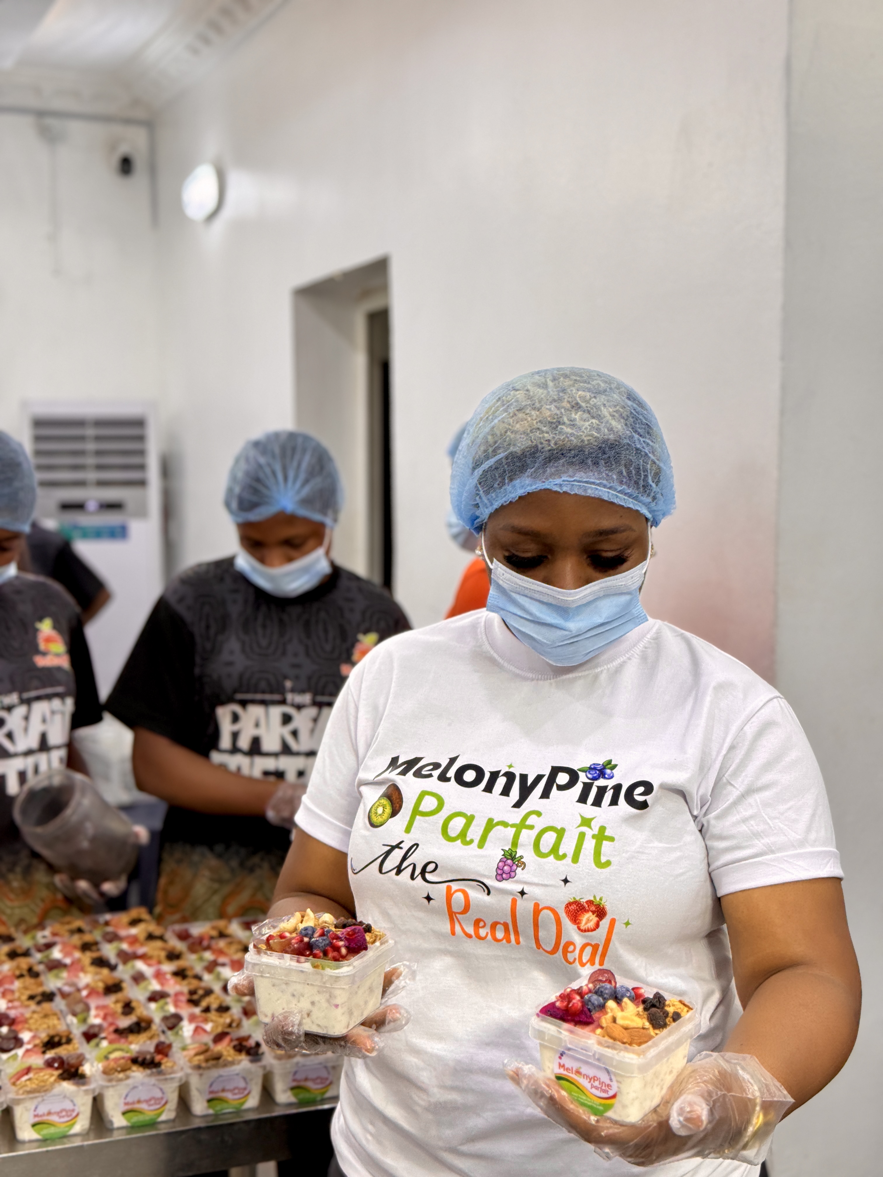 Augusta Nkanu preparing MelonyPine parfaits with members of her production team